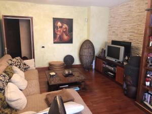 een woonkamer met een bank en een tv bij Casa M. in Candelaria