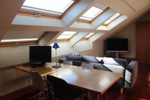 a room with a table and a couch and skylights at A casa Rosa- Ático en el centro de Vigo in Vigo