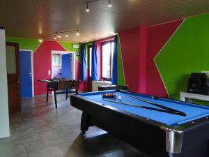 uma mesa de bilhar num quarto com paredes coloridas em Chambres d'hôtes des Ardennes em Porcheresse