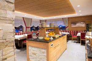 a restaurant with a counter with bowls of fruit on it at B&B Residence Adria in Corvara in Badia