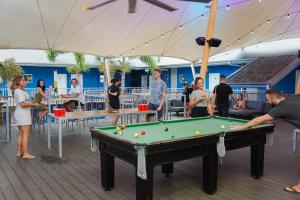 a group of people standing around a pool table at Bounce Cairns in Cairns