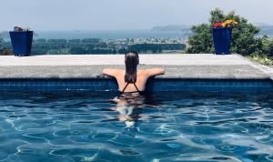 a woman is sitting in a swimming pool at WoodyHanger Lodge in Whitianga