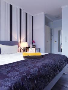 ein Schlafzimmer mit einem großen Bett mit einer blauen Decke in der Unterkunft Hotel garni Morsum in Nordstrand