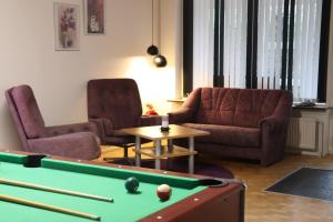 a living room with a pool table and two chairs at Holstebro Townside House in Holstebro