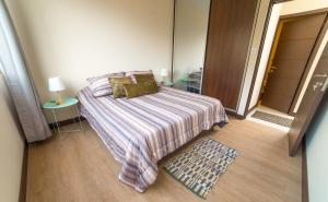 Dormitorio pequeño con cama y espejo en Apartamento Mira 2, en Cochabamba