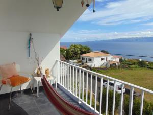 a hammock on a balcony with a view of the ocean at Casa do Carroça in Terreiros