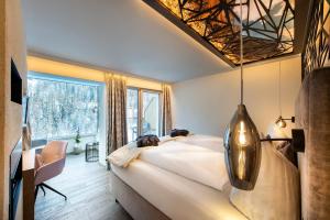 a bedroom with a large bed and a large window at LARET private Boutique Hotel - Adults only in Samnaun