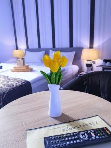 un jarrón con flores amarillas sobre una mesa con un teclado en Hotel garni Morsum, en Nordstrand