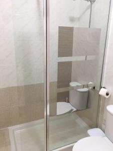 ein Badezimmer mit Glasdusche und Toilette in der Unterkunft Apartamento Pasaje Ronda Centro in Ronda + 7 Fotos