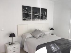 ein Schlafzimmer mit einem Bett mit drei Bildern an der Wand in der Unterkunft Apartamento Pasaje Ronda Centro in Ronda
