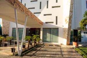 a building with palm trees in front of it at Hotel Playa Encantada in Playa del Carmen +54 photos