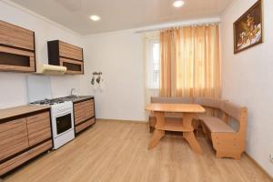 ゴルビツカヤにあるDionis Guest Houseの小さなキッチン(木製テーブル、テーブル、椅子付)