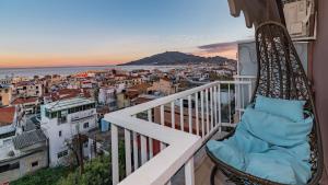 a balcony with a chair and a view of a city at Eolia Apartment in Zakynthos Town