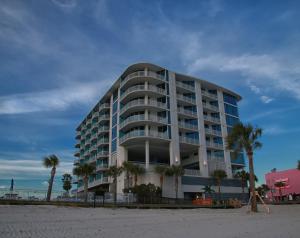 - un bâtiment sur la plage avec des palmiers devant dans l'établissement South Beach Biloxi Hotel & Suites, à Biloxi