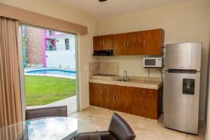 a kitchen with a stainless steel refrigerator and a table at Hotel Playa Encantada in Playa del Carmen