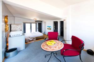 Habitación con 2 sillas rojas, mesa y cama en Topfloor stylish apartment with Acropolis view! en Athens