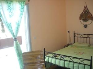 - une chambre avec un lit, une fenêtre et une chaise dans l'établissement EDEN BEACH SAINT-LOUIS, à Saint-Louis