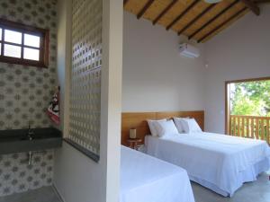 a bedroom with a white bed and a window at Lagoa Seca Hotel Rural in São Lourenço