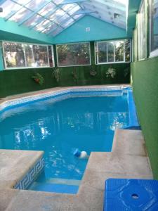 a swimming pool with blue water in a building at Pinamar De La Lisa in Pinamar