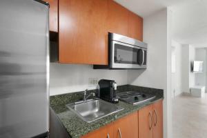 eine Küche mit einer Spüle und einer Mikrowelle in der Unterkunft Centric Modern, Stylish Brickell / Miami + FREE Parking in Miami