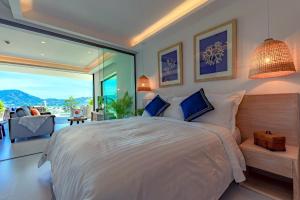 - une chambre avec un grand lit et une grande fenêtre dans l'établissement Patong Heights, à Patong Beach