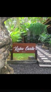 a sign that says nixon castle on a bench at Kubu Carik in Legian