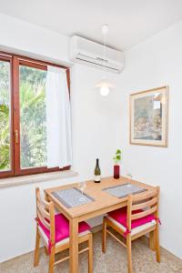 einem Esstisch mit 2 Stühlen und einem Fenster in der Unterkunft Apartments Alluro in Rovinj