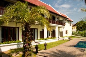 a house with a palm tree and a swimming pool at Sunrise Garden House - Luang Prabang in Luang Prabang