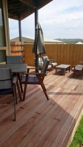 a wooden deck with a table and chairs and an umbrella at Number 9 Leisure Stay in Port Campbell