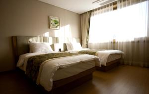 een hotelkamer met 2 bedden en een raam bij STX Resort in Mungyeong