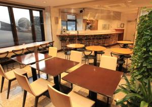 a restaurant with tables and chairs and a bar at Urban Hotel Kyoto in Kyoto