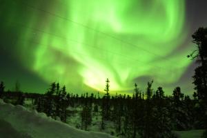 uma imagem da aurora dançando no céu em Aurora deluxe Guest House em Yellowknife