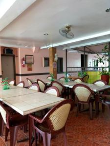 a restaurant with tables and chairs in a room at Sola Eleganza Apartelle in Manila