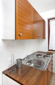 eine Küche mit Spüle und Holzschränken in der Unterkunft Apartments Alluro in Rovinj
