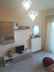  Il comprend un salon doté d'une télévision et d'un bureau avec un moniteur. dans l'établissement Sea view cozy studio near center of Rethymno town&free parking, à Réthymnon