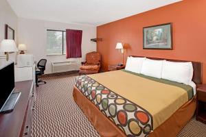 a hotel room with a bed and a television at Super 8 by Wyndham Crystal Lake in Crystal Lake