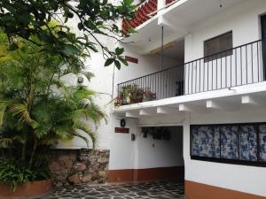 a white building with palm trees and a balcony at Hotel Posada Santa Anita in Taxco de Alarcón
