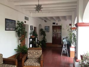 a lobby with a chair and some plants at Hotel Posada Santa Anita in Taxco de Alarcón