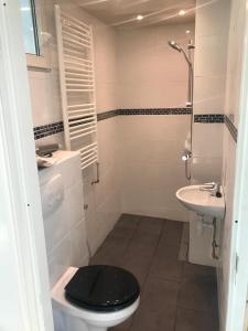 a bathroom with a black toilet and a sink at Hababa Short Stay in Amsterdam +23 photos