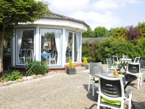 a patio with a bunch of chairs and tables at Hotel garni Morsum in Nordstrand