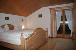 - une chambre avec un lit en bois et une fenêtre dans l'établissement Ferienwohnung Heilingbrunner, à Bad Wiessee