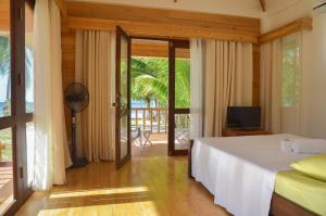 a bedroom with a bed and a sliding glass door at White Villas Resort in Siquijor