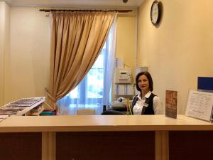 Eine Frau, die an einem Schreibtisch in einem Zimmer sitzt. in der Unterkunft Gonchar Hotel in Kiew