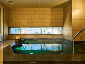 a large swimming pool in a room with a large window at Super Hotel Mihara Ekimae in Mihara