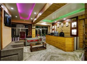 two people standing at a bar in a lobby at Hotel White Yak in Darjeeling