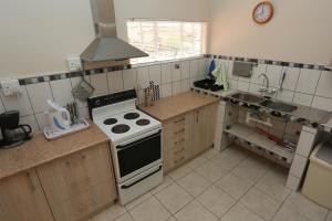 a kitchen with a stove and a sink at Orange House Self Catering in Aus