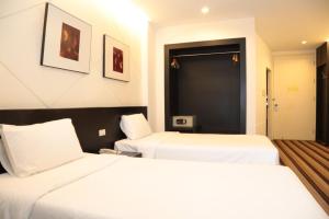 2 łóżka w pokoju hotelowym z białą pościelą w obiekcie Miracle Suvarnabhumi Airport w Lat Krabang