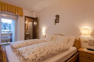 a bedroom with two beds and a window and lights at Digonera Historic Hotel B&B in Rocca Pietore