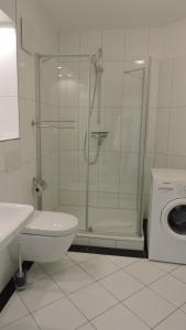 a bathroom with a shower and a sink and a washing machine at Ferienwohnung Timmendorfer in Timmendorfer Strand