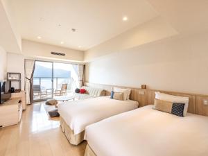 a hotel room with two beds and a large window at Hakone Ashinoko Hanaori in Hakone